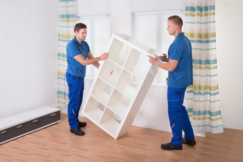 A moving team managing furniture and boxes during house removals in Merton